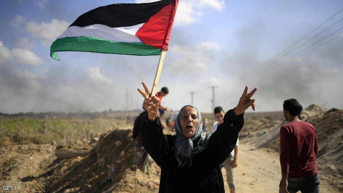 A Palestinian woman holds a national flag during clashes with Israeli security forces near the border fence between Israel and the Gaza Strip on October 9, 2015 east of Gaza City. A week of violence between Israelis and Palestinians spread to the Gaza Strip, with Israeli troops killing five people in clashes on the border and Islamist movement Hamas calling for more unrest. AFP PHOTO / MOHAMMED ABED (Photo credit should read MOHAMMED ABED/AFP/Getty Images)