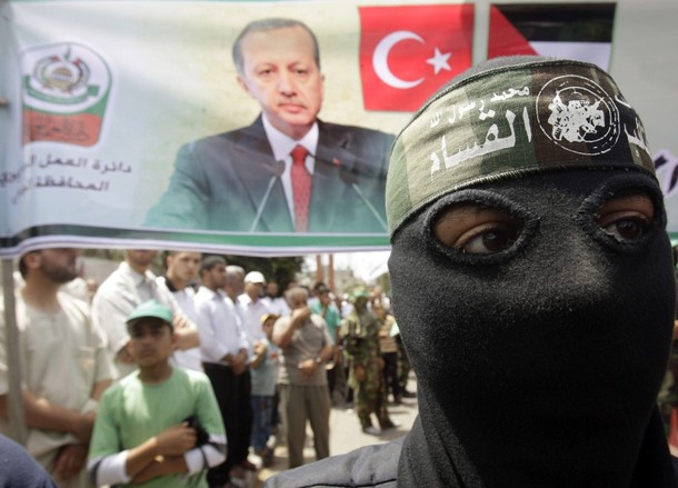 A masked member of Hamas stands in front of a banner depicting Turkey's Prime Minister Tayyip Erdogan during a protest in Central Gaza Strip June 4, 2010, against Israel's interception of Gaza-bound ships. Israeli marines stormed a  Turkish aid ship bound for Gaza on Monday and at least nine pro-Palestinian activists were killed, triggering a diplomatic crisis and an emergency session of the U.N. Security Council. REUTERS/Ibraheem Abu Mustafa (GAZA - Tags: POLITICS CIVIL UNREST)