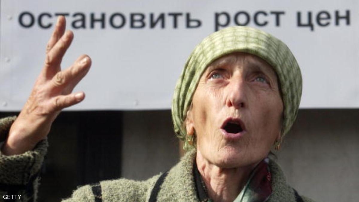 A woman shouts in front of a poster reading "The resignation of Putin if he doesn't stop prices going up" during a rally in Vladikavkaz, 13 October 2007. AFP PHOTO / KAZBEK BASAYEV (Photo credit should read KAZBEK BASAYEV/AFP/Getty Images)