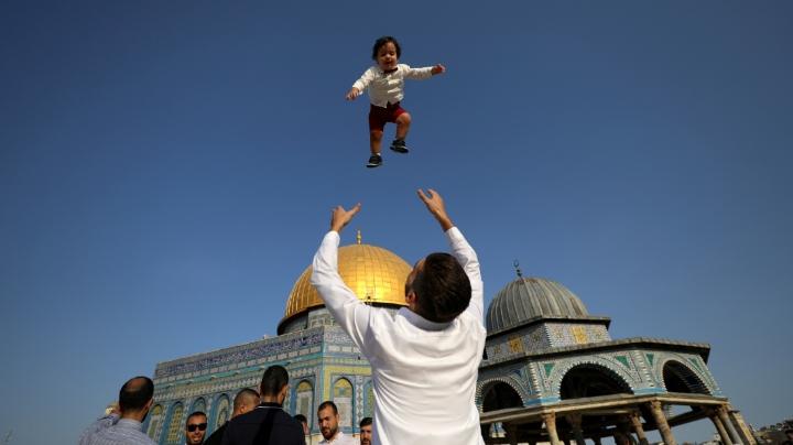 Seorang warga Palestina bermain dengan anaknya saat merayakan Idul Adha di Kompleks Masjid Al Aqsa di Yerusalem, 20 Juli 2021. Warga Palestina bersuka cita merayakan Idul Adha dengan berkumpul di Masjid Al Aqsa. REUTERS/Ammar Awad
